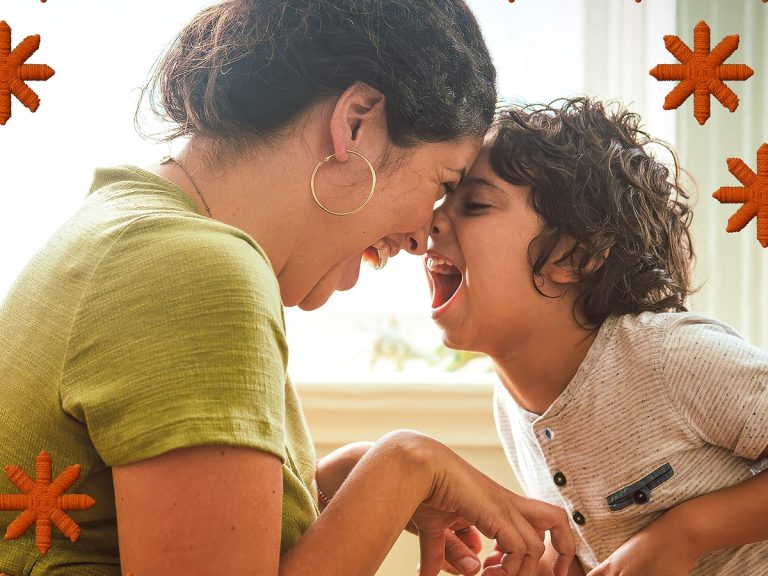 Mother and child, laughing with their for foreheads pressed together.