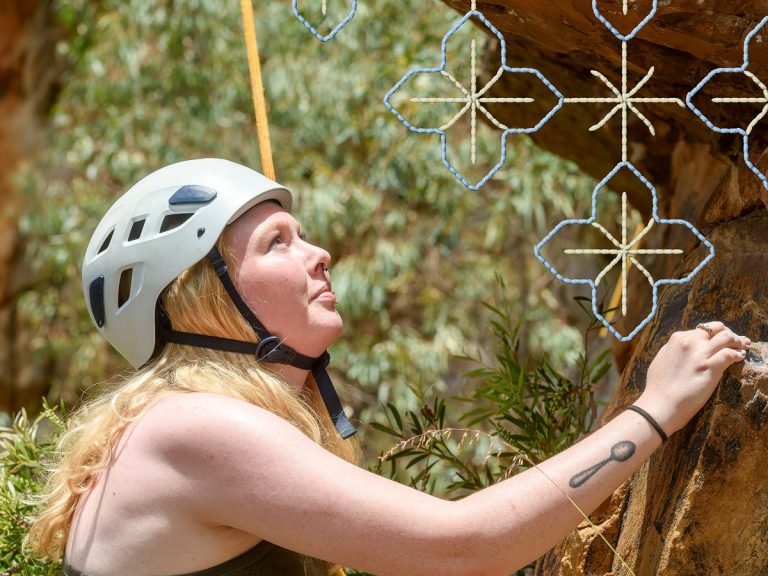 Young adult rock climbing outdoors.